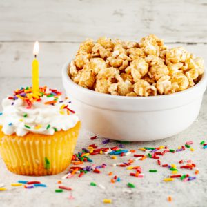 Cupcake with sprinkles, popcorn in bowl.